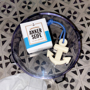 Anker Seife eine maritime Seife in Ankerform mit Kordel neben Verpackung auf einem Tisch