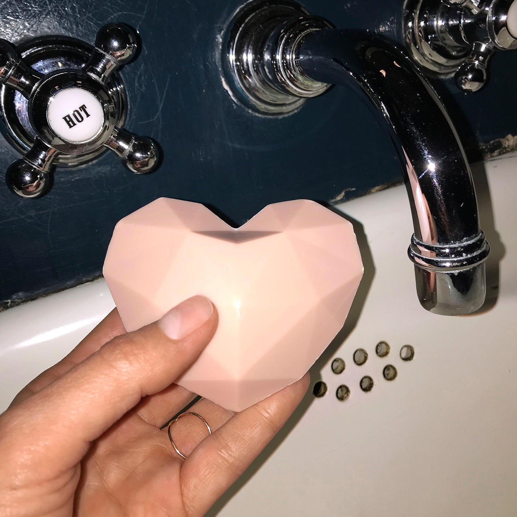 heart soap herzseife in der hand neben wasserhahn